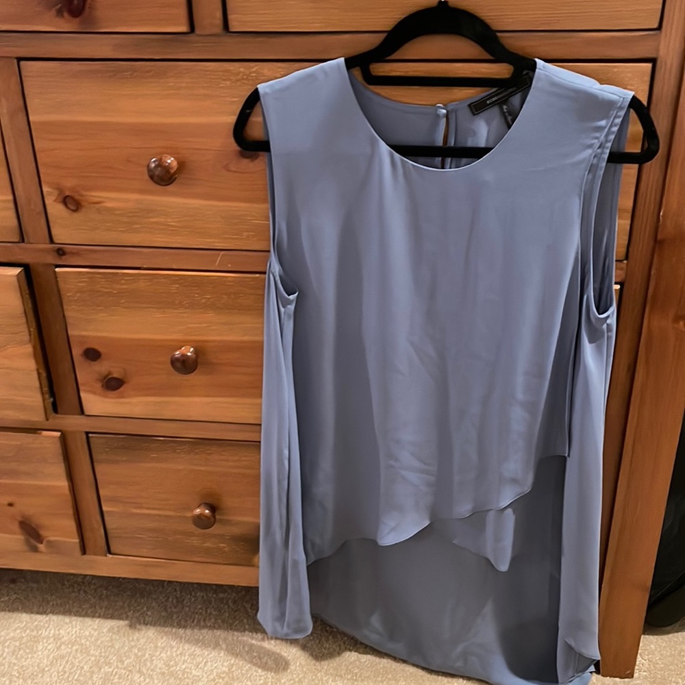 BCBG light powder blue shirt in front , long in back shift on top .